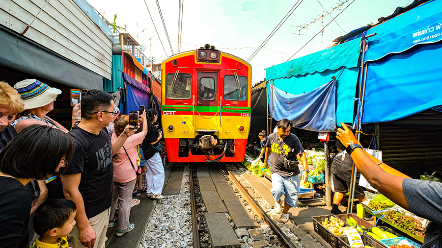 Le train qui traverse le Maeklong Railway Market à Bangkok et qui frôle les visiteurs